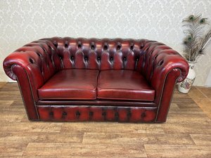 Chesterfield pohovka z červené kůže s klasickým knoflíkovým prošíváním